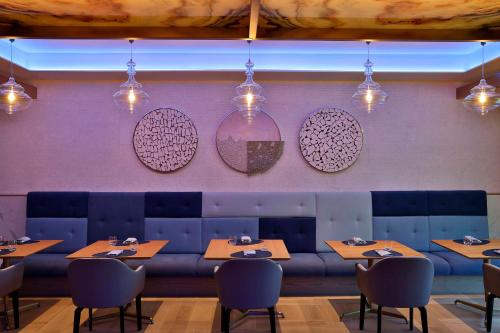a dining room with tables and chairs and pendant lights at Hilton Abu Dhabi Yas Island in Abu Dhabi