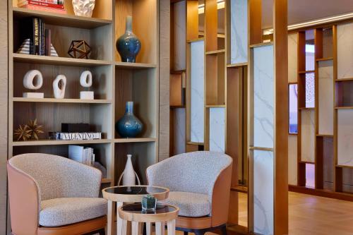 two chairs and a table in a room with shelves at Hilton Abu Dhabi Yas Island in Abu Dhabi