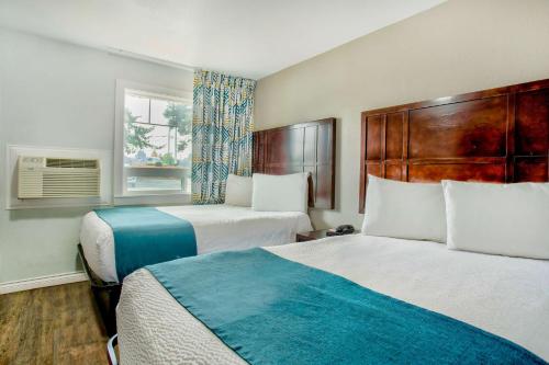 a hotel room with two beds and a window at Studio 6 Suites - Albany, OR in Albany