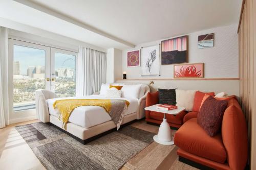 a bedroom with a bed and a couch and a chair at Virgin Hotels Las Vegas, Curio Collection by Hilton in Las Vegas