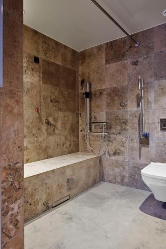 a bathroom with a shower and a tub and a toilet at Telegraphenamt in Berlin