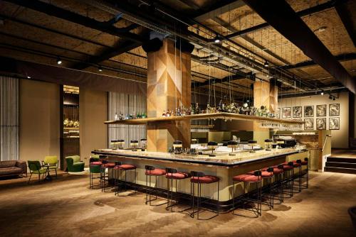 a restaurant with a bar with red stools at Telegraphenamt in Berlin