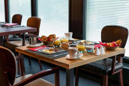 a wooden table with breakfast foods on it at Hilton Geneva Hotel and Conference Centre in Geneva
