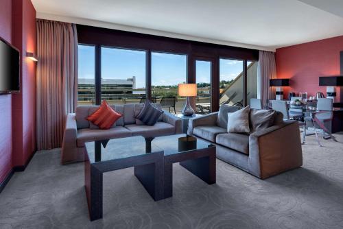a living room with two couches and a table at Hilton Geneva Hotel and Conference Centre in Geneva
