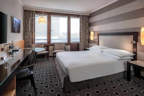 a hotel room with a bed and a desk at Hilton Geneva Hotel and Conference Centre in Geneva