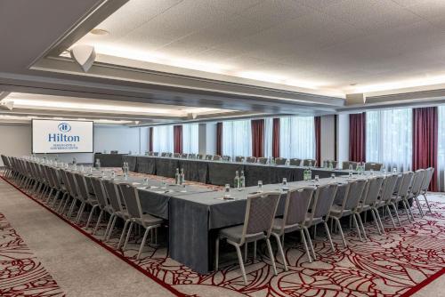 a conference room with a long table and chairs at Hilton Geneva Hotel and Conference Centre in Geneva