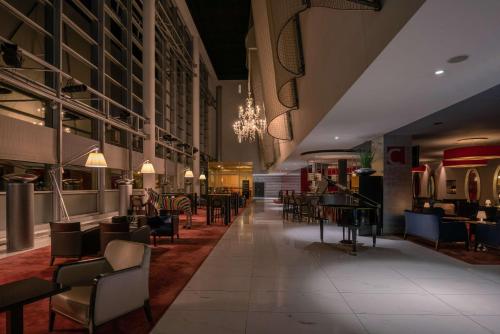 a restaurant with tables and chairs in a building at Hilton Geneva Hotel and Conference Centre in Geneva
