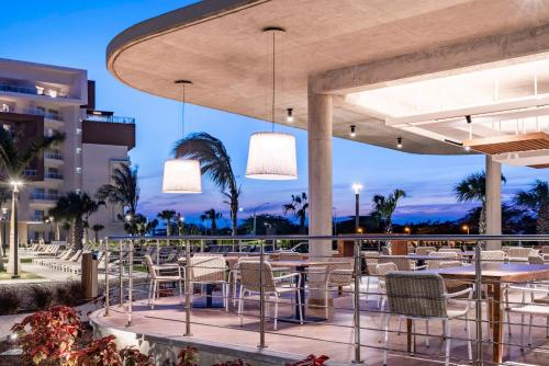 ein Restaurant mit Tischen und Stühlen auf einer Terrasse in der Unterkunft Embassy Suites By Hilton Aruba Resort in Palm-Eagle Beach