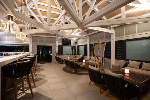 a lobby with a bar and tables and chairs at DoubleTree by Hilton Noumea Ilot Maitre Resort in Ilot Maitre