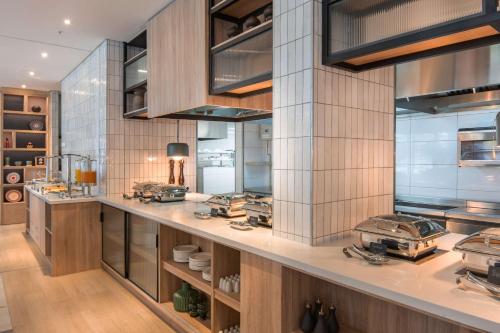 a large kitchen with a counter with many appliances at Hilton Garden Inn Umhlanga Arch in Durban