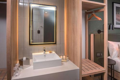 a bathroom with a white sink and a mirror at Hilton Garden Inn Umhlanga Arch in Durban