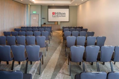 a conference room with blue chairs and a whiteboard at Hilton Garden Inn Umhlanga Arch in Durban