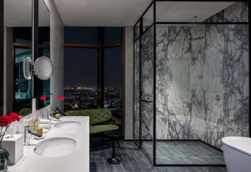 迪拜DoubleTree by Hilton Dubai M Square Hotel & Residences的带两个水槽和淋浴的浴室