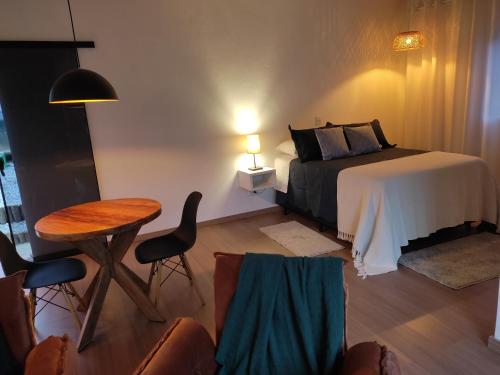 a bedroom with a bed and a table and chairs at Angatu chalé in Gonçalves