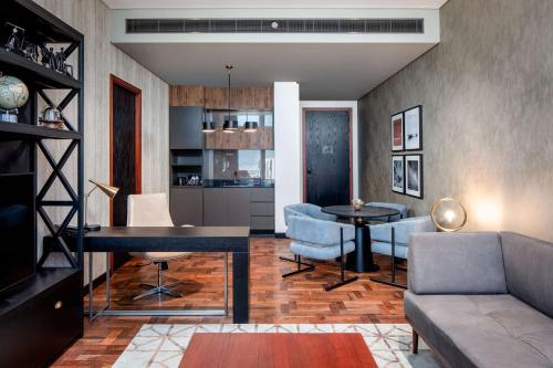 a living room with a couch and a table at DoubleTree by Hilton Dubai M Square Hotel & Residences in Dubai