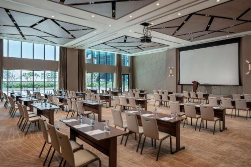 a conference room with tables and chairs and a whiteboard at DoubleTree by Hilton Dubai M Square Hotel & Residences in Dubai