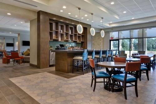 a restaurant with tables and chairs and a bar at Home2 Suites By Hilton Orlando Flamingo Crossings, FL in Orlando