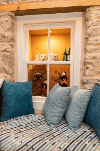 a couch with blue pillows in a room at Traditional Cottage with Private Hot Tub in the Heart of Donegal in Letterkenny