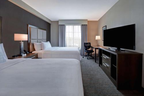 Habitación de hotel con 2 camas y TV de pantalla plana. en Homewood Suites By Hilton Orlando Flamingo Crossings, Fl en Orlando