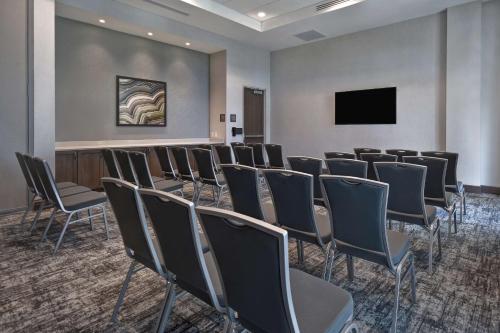 a conference room with chairs and a flat screen tv at Homewood Suites By Hilton Orlando Flamingo Crossings, Fl in Orlando