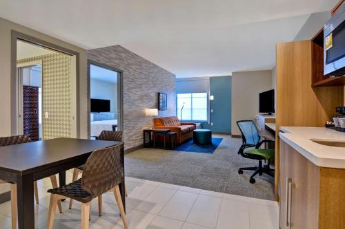 a kitchen and living room with a table and chairs at Home2 Suites By Hilton Orlando Flamingo Crossings, FL in Orlando