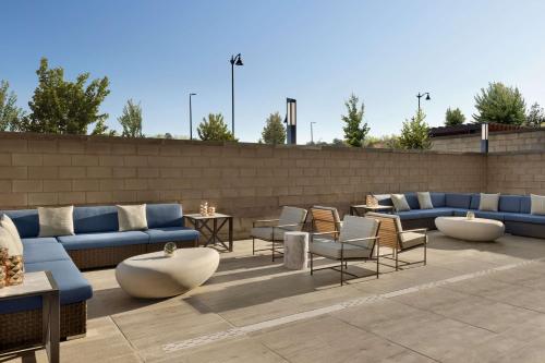 eine Terrasse mit Sofas, Tischen und Stühlen in der Unterkunft Hilton Alpharetta Atlanta in Alpharetta