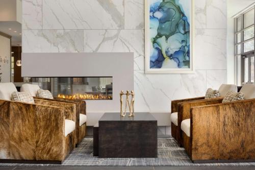 a lobby with couches and a table and a fireplace at Hilton Alpharetta Atlanta in Alpharetta