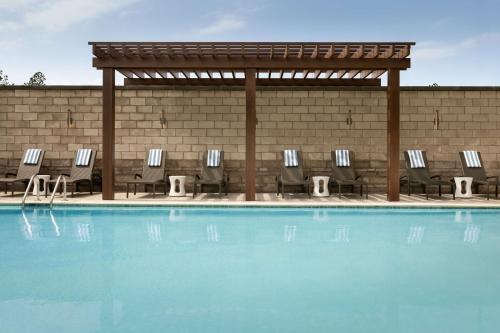 a group of chairs sitting next to a swimming pool at Hilton Alpharetta Atlanta in Alpharetta