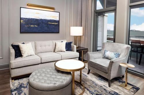 a living room with a couch and two chairs and a table at Hilton Club Liberty Place Charleston in Charleston