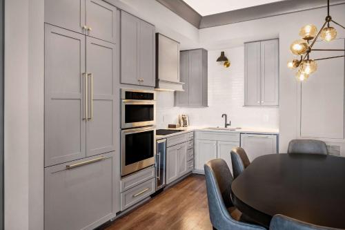 a kitchen with white cabinets and a table with chairs at Hilton Club Liberty Place Charleston in Charleston