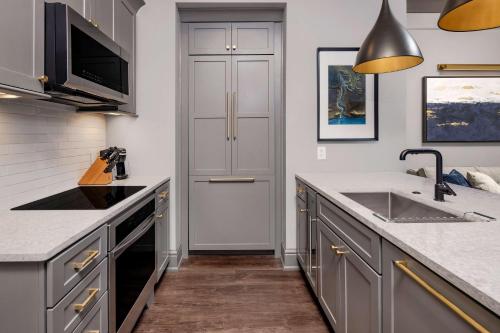a kitchen with gray cabinets and a sink at Hilton Club Liberty Place Charleston in Charleston