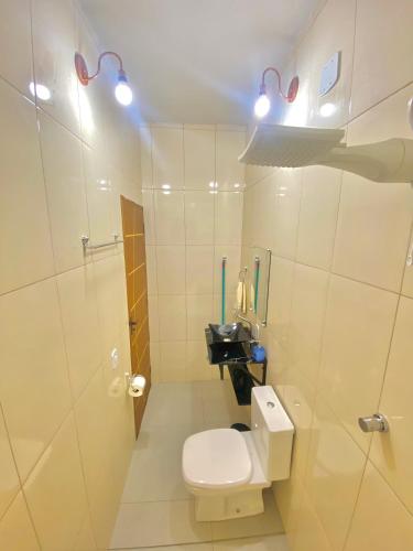 a white bathroom with a toilet and a sink at Apartamentos C7 in Cunha