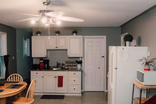 a kitchen with white cabinets and a white refrigerator at Sun Chaser Bay in Carrying Place