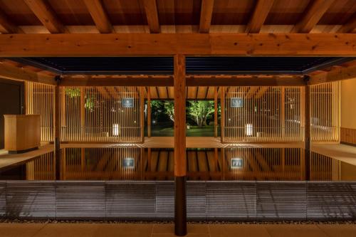a room with a large window and a wooden ceiling at ROKU KYOTO, LXR Hotels & Resorts in Kyoto