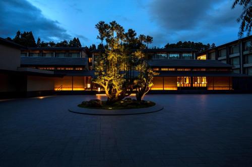 um edifício com uma árvore em frente a um edifício em ROKU KYOTO, LXR Hotels & Resorts em Quioto