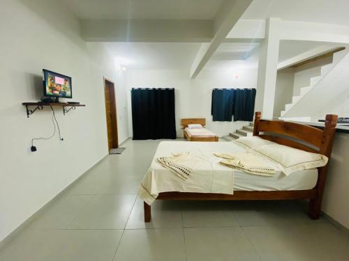 a bedroom with a bed and a television in it at Apartamentos C7 in Cunha