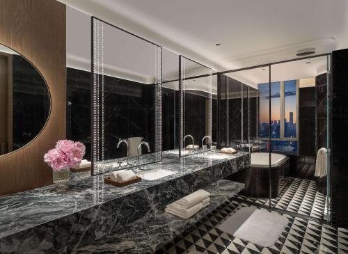 a bathroom with two sinks and a large mirror at Conrad Urumqi in Ürümqi