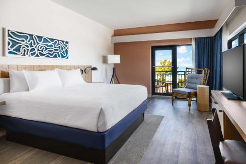 a hotel room with a bed and a television at Hilton Garden Inn St. Pete Beach, FL in St Pete Beach