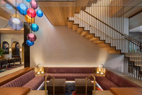 ニューヨークにあるMotto by Hilton New York City Chelseaのソファと階段のあるロビー