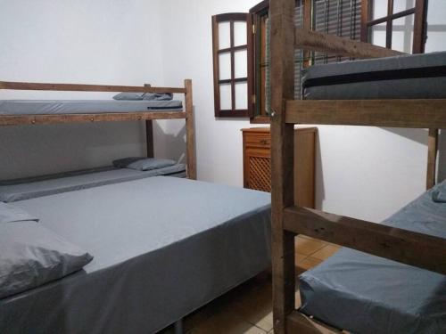 um quarto com três beliches num quarto em Chácara dos Sonhos em Mairiporã em Mairiporã