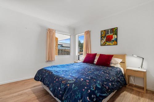 a bedroom with a bed and a window at Fisherman's Friend - Bowentown Holiday Home in Waihi