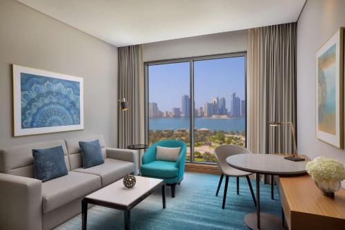 a living room with a couch and a table at DoubleTree by Hilton Sharjah Waterfront Hotel And Residences in Sharjah