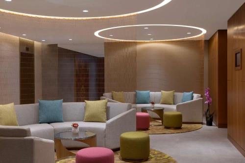 a lobby with couches and colorful chairs and tables at DoubleTree by Hilton Sharjah Waterfront Hotel And Residences in Sharjah