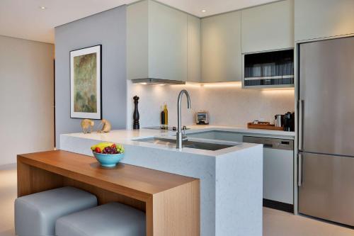 a kitchen with a sink and a bowl of fruit on a counter at DoubleTree by Hilton Sharjah Waterfront Hotel And Residences in Sharjah