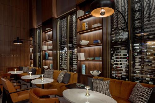 a restaurant with tables and chairs and a wine cellar at Conrad Nashville in Nashville