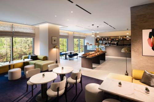 a restaurant with tables and chairs and a bar at DoubleTree By Hilton Seoul Pangyo Residences in Seongnam