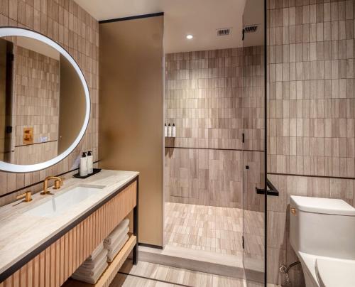 a bathroom with a shower and a sink and a toilet at Tempo By Hilton New York Times Square in New York