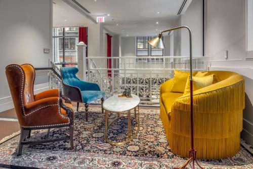 a living room with a yellow couch and two chairs at Canopy By Hilton Chicago Central Loop in Chicago