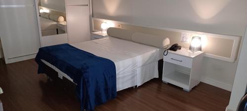 Habitación pequeña con cama y espejo. en Apart hotel otima localizaçao em Brasilia, en Brasilia