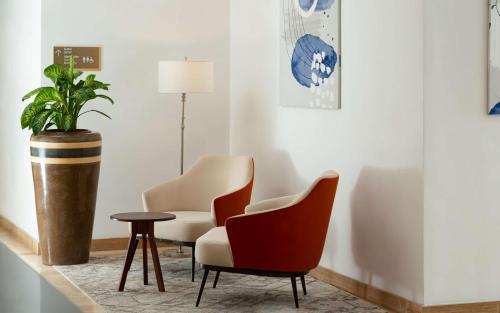a waiting room with chairs and a potted plant at DoubleTree by Hilton Shymkent in Shymkent